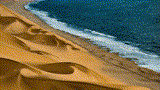 Seas crashing into sandy dunes of a beach